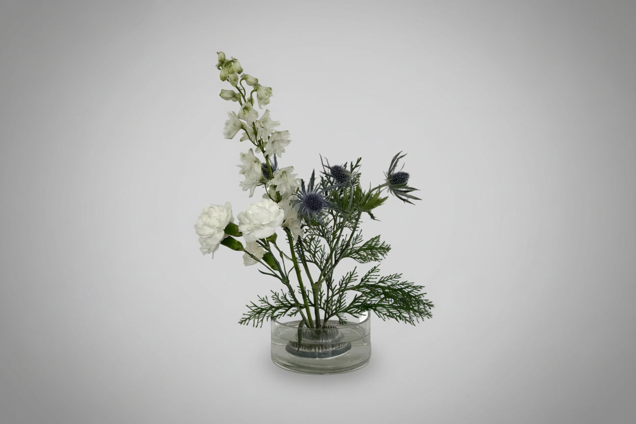 Flower arrangement in a clear vase on a light gray background