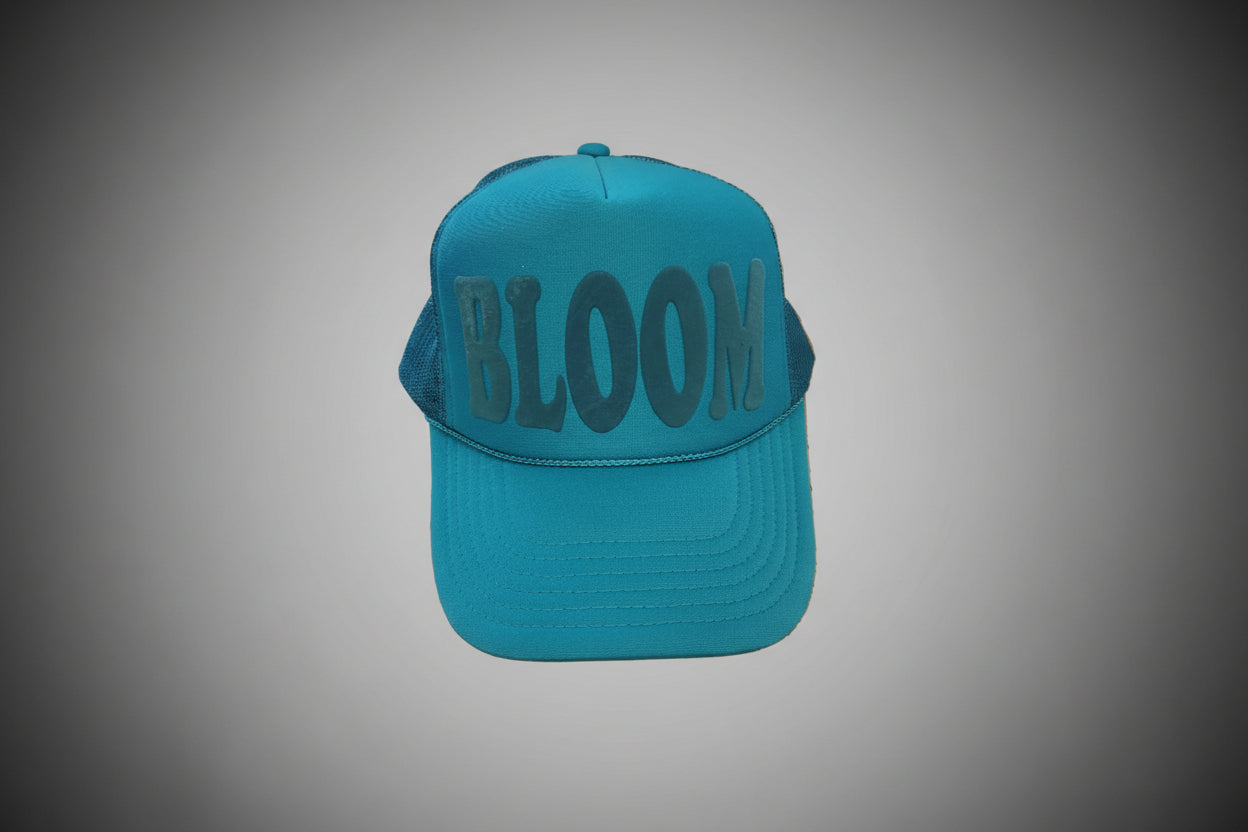 Blue cap with 'BLOOM' text on a wooden surface