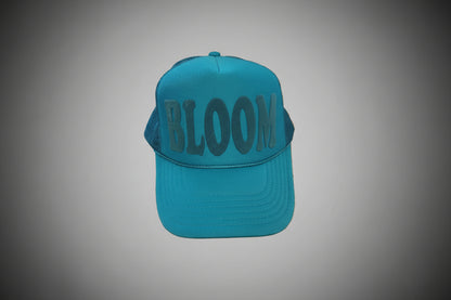 Blue cap with 'BLOOM' text on a wooden surface