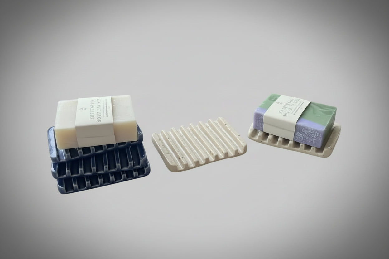 A collection of ceramic soap rests with bars of soap on them 
